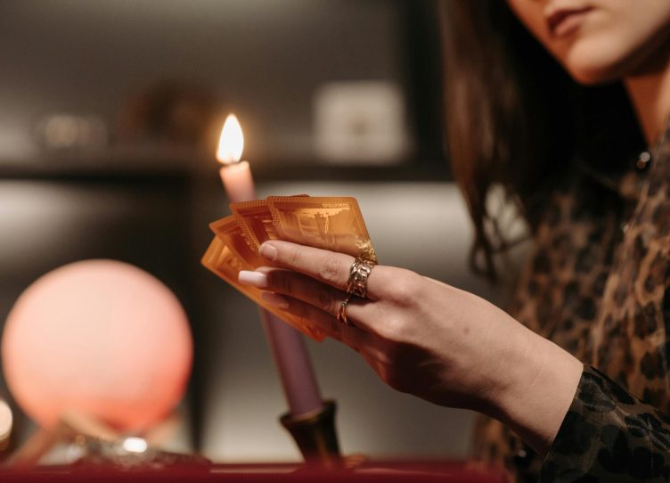 Close-up view of a candlelit tarot reading session, highlighting mystery and focus.